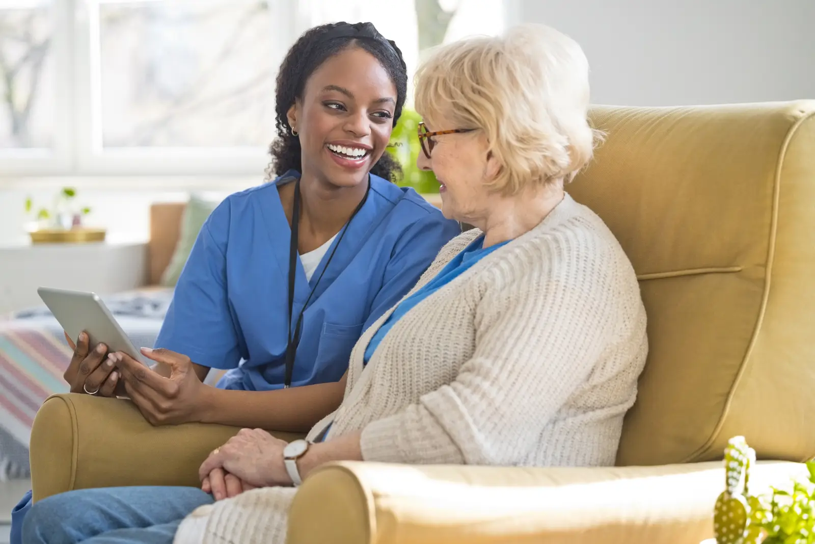 A caregiver sitting with an older adult and reviewing information together.