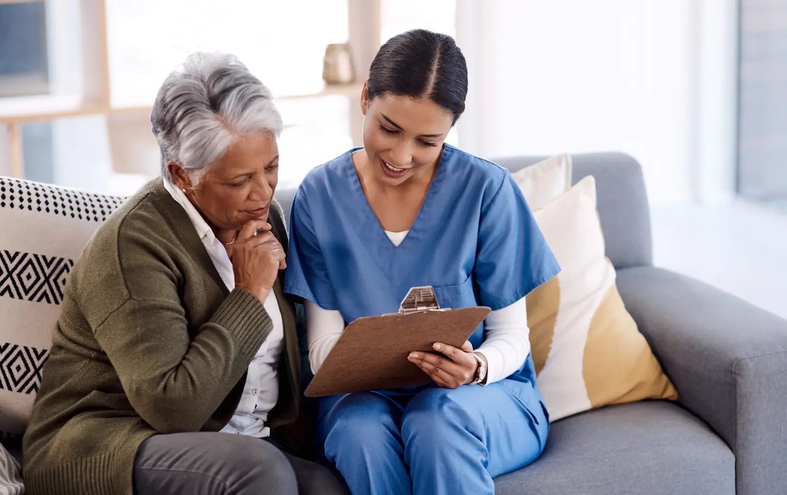 A Prime Health caregiver reviewing care notes with an older adult at home.